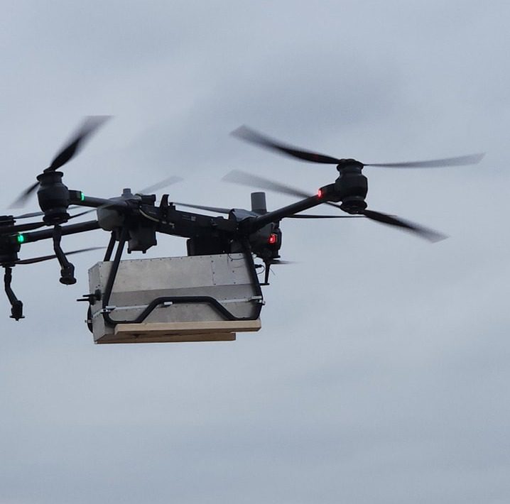 Drone delivering cargo in flight.